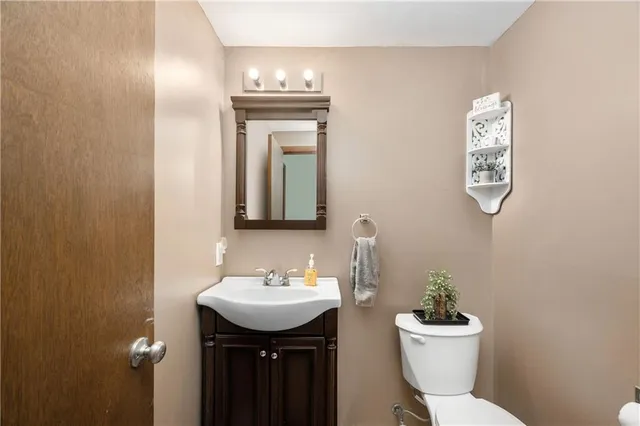 a bathroom with a toilet a sink and mirror