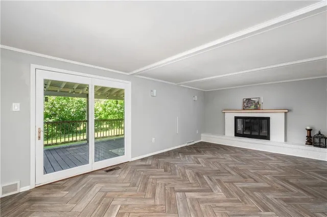 a view of an empty room with a fireplace and a window