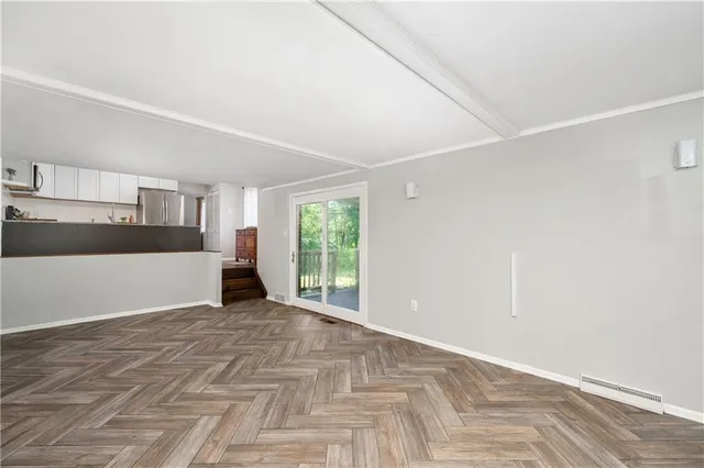 a view of a big room with wooden floor and windows