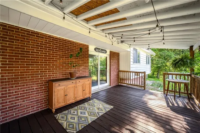 a view of a porch with wooden floor in front of house