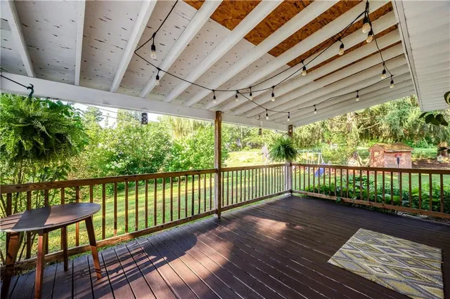 a view of a house with a big yard potted plants and large tree