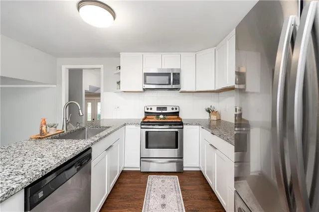 a kitchen with stainless steel appliances granite countertop a sink stove and refrigerator