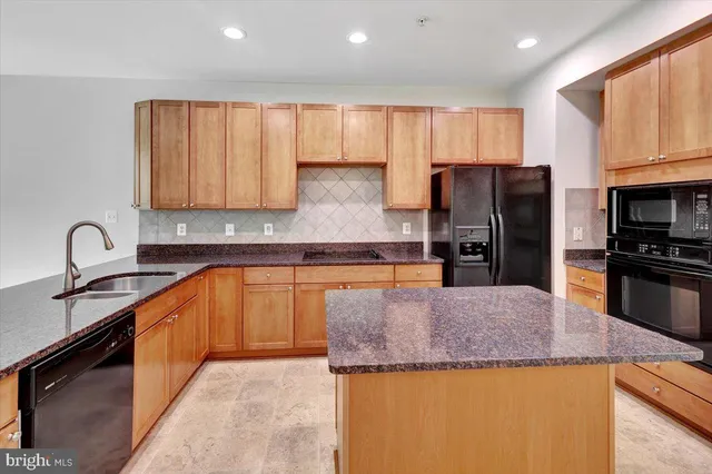a kitchen with granite countertop a refrigerator and a sink