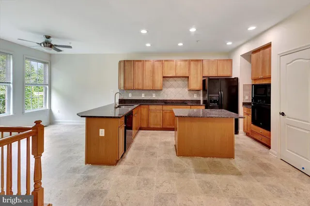 a kitchen with stainless steel appliances granite countertop a refrigerator a stove top oven a sink and dishwasher
