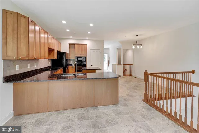 a kitchen with stainless steel appliances a sink a counter top space cabinets and a window