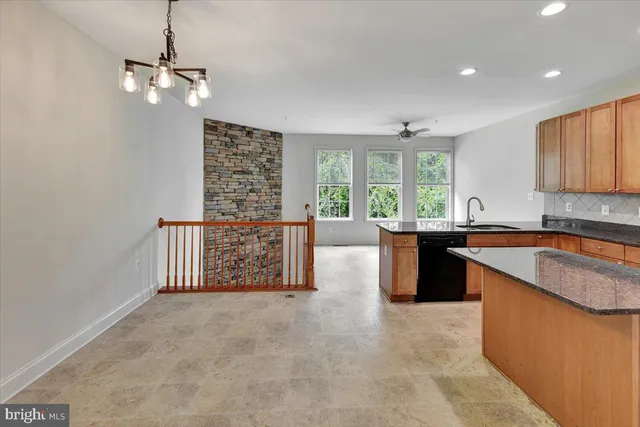 a kitchen with stainless steel appliances granite countertop a sink a stove and a refrigerator