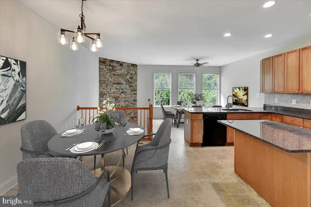 a open kitchen with stainless steel appliances granite countertop a sink a stove a dining table and chairs