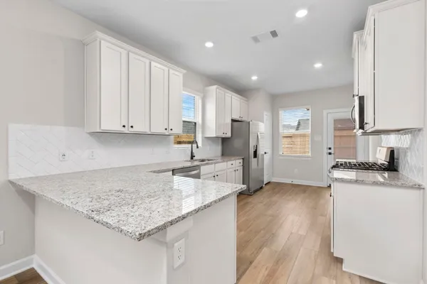 a kitchen with stainless steel appliances granite countertop a sink stove and refrigerator