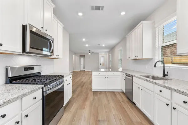 a kitchen with a sink stove and microwave