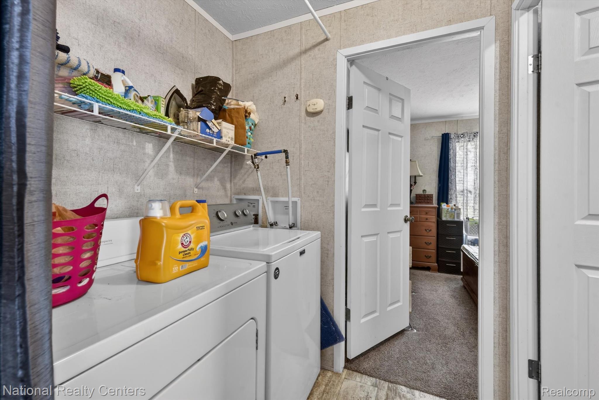 2735 South Wagner Road, Unit 103 Ann Arbor, MI 48103 - Photo 15 of 20 Laundry area with washer and clothes dryer, a textured ceiling, ornamental molding, and light carpet