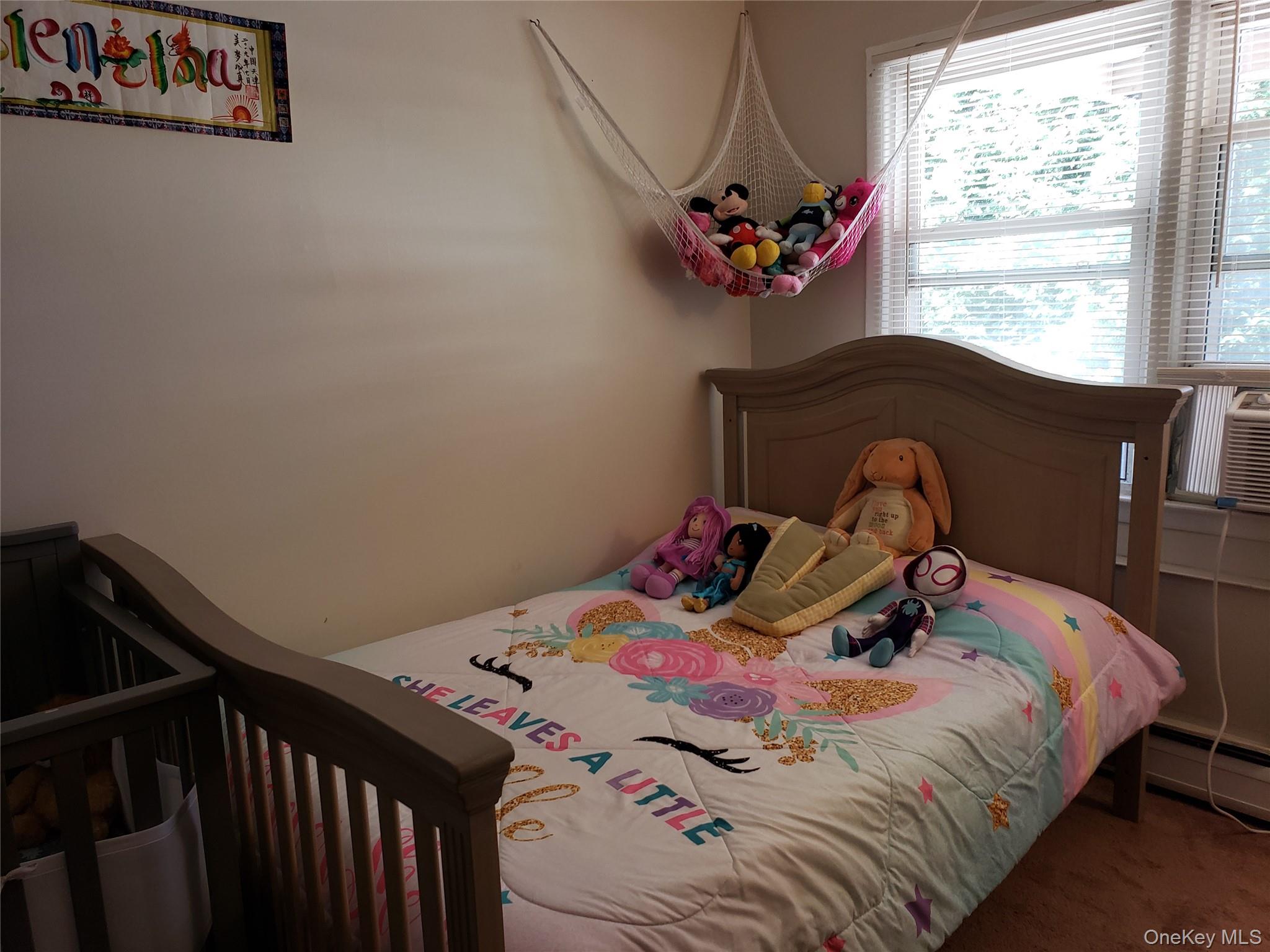 16-74 Bell Boulevard Queens, NY 11360 - Photo 11 of 20 Carpeted bedroom featuring a baseboard heating unit and a nursery area