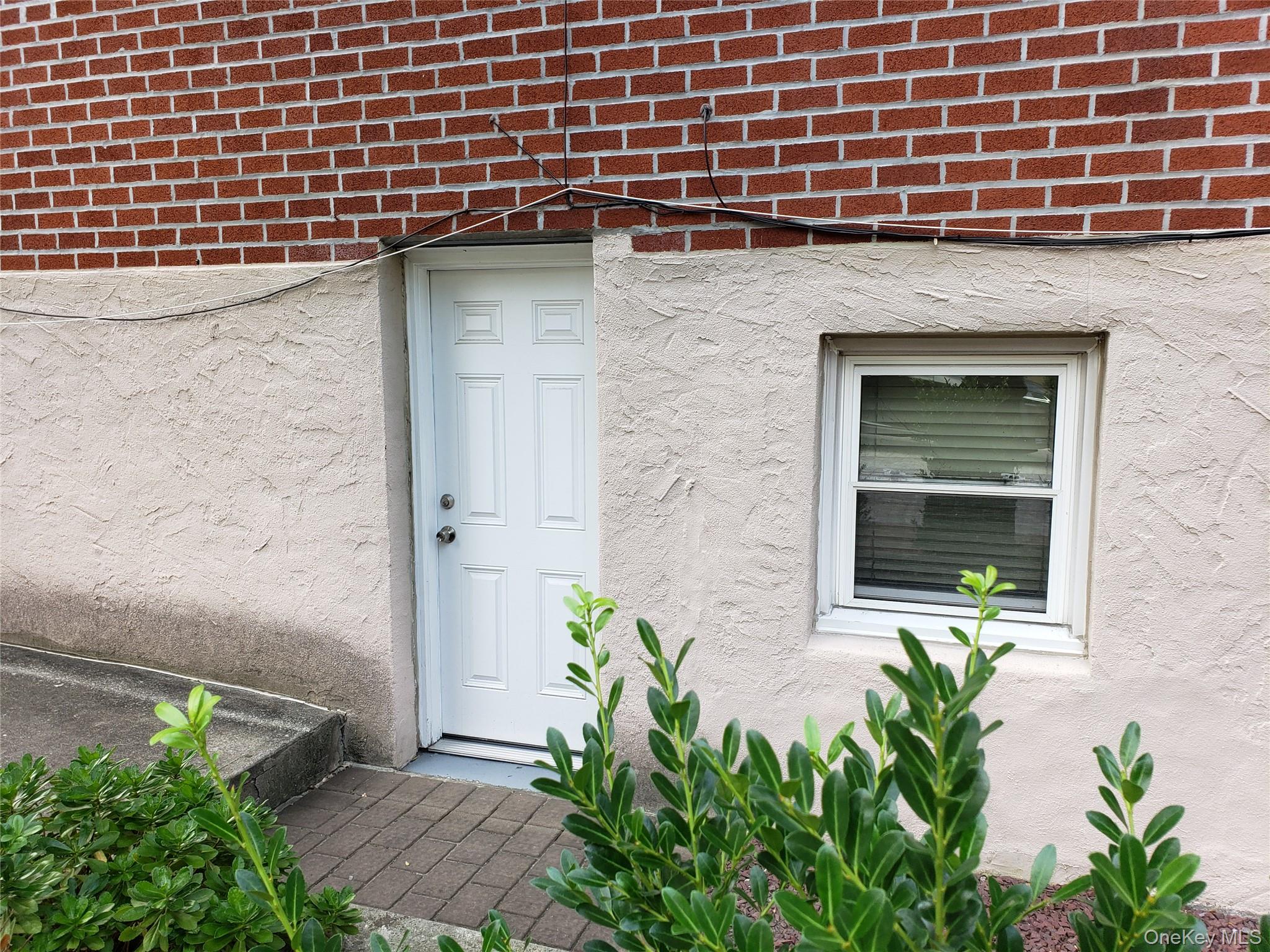 16-74 Bell Boulevard Queens, NY 11360 - Photo 4 of 20 Side Entrance to garage with stucco siding