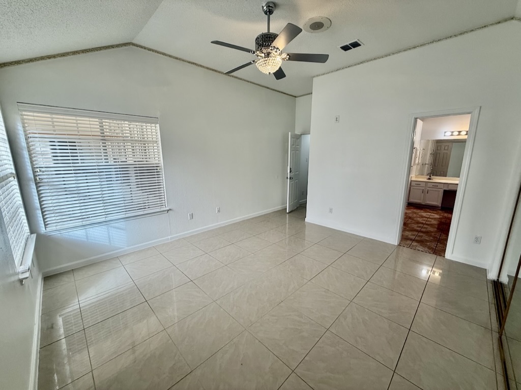 604 Cactus Bend Drive Pflugerville, TX 78660 - Photo 16 of 29 Unfurnished bedroom with vaulted ceiling, a textured ceiling, light tile patterned flooring, and visible vents