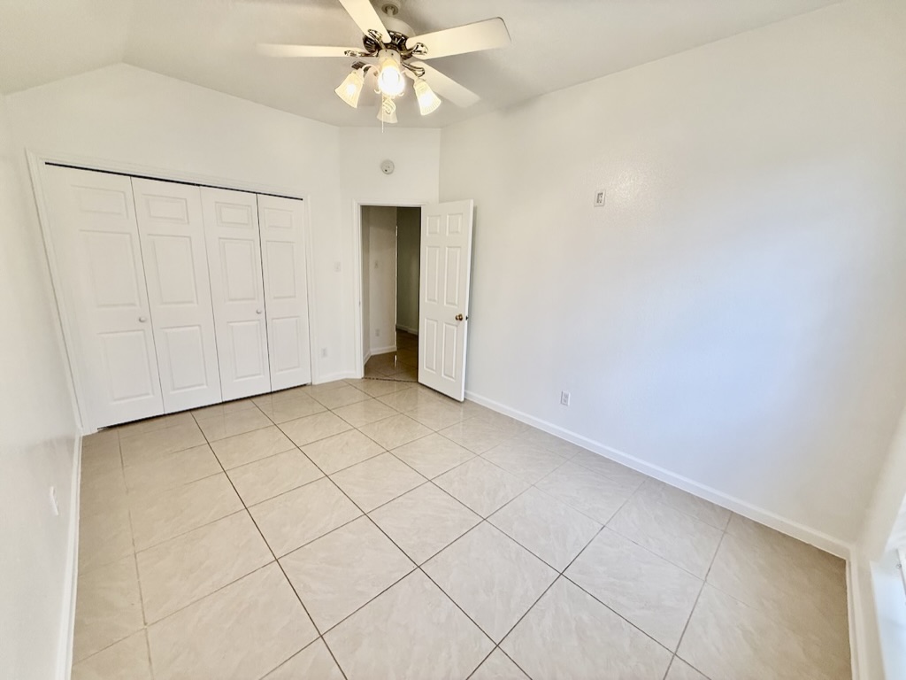 604 Cactus Bend Drive Pflugerville, TX 78660 - Photo 20 of 29 Unfurnished bedroom featuring light tile patterned floors, lofted ceiling, a closet, a ceiling fan, and baseboards