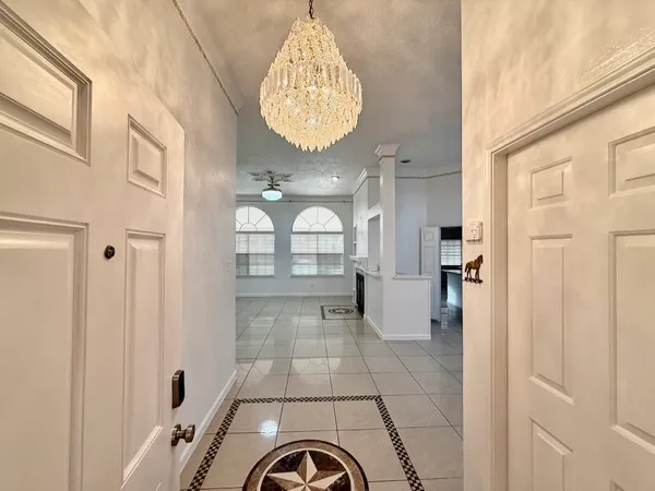 a view of entryway with livingroom and chandelier