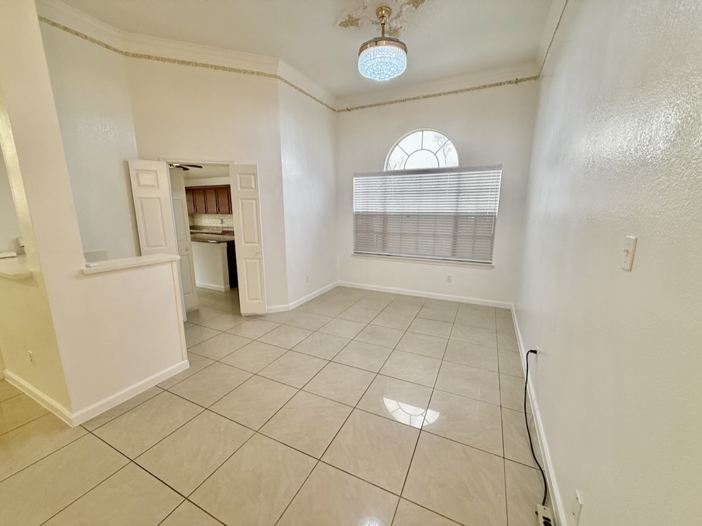 604 Cactus Bend Drive Pflugerville, TX 78660 - Photo 5 of 29 Spare room with light tile patterned floors, baseboards, and crown molding