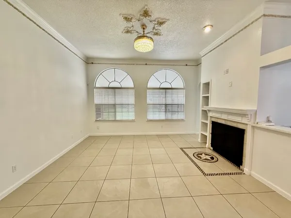a view of an empty room with a fireplace and a window