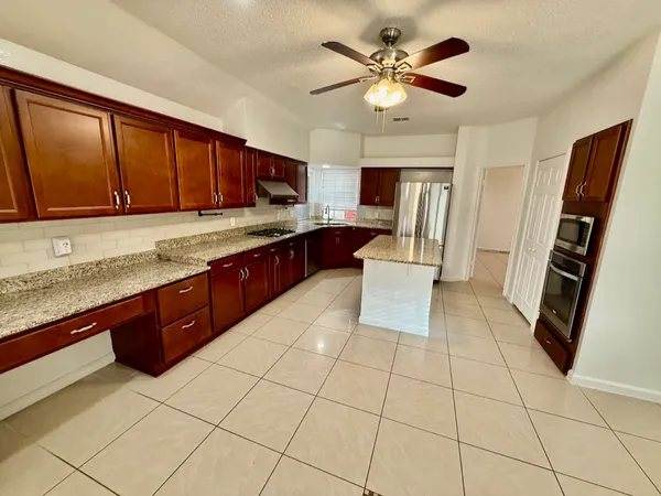 a large kitchen with stainless steel appliances granite countertop a sink and cabinets