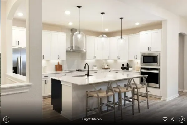 a kitchen with stainless steel appliances kitchen island granite countertop a sink a stove and a refrigerator