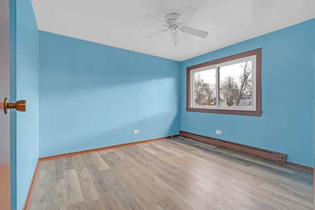 a view of an empty room with a window and a ceiling fan