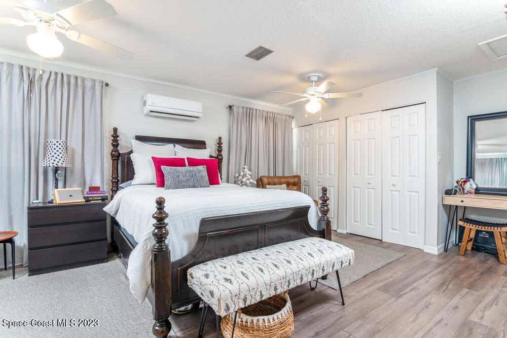 2449 Apache Drive Melbourne, FL 32935 - Photo 33 of 61 a bedroom with a bed and a chandelier