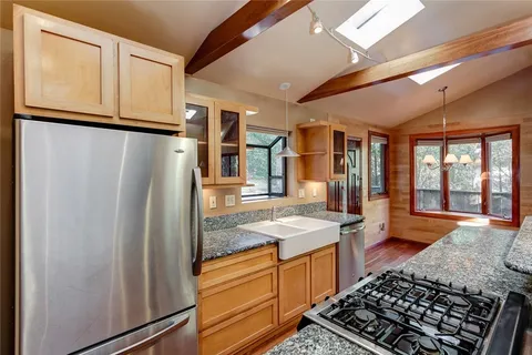 a kitchen with stainless steel appliances granite countertop a refrigerator and a sink