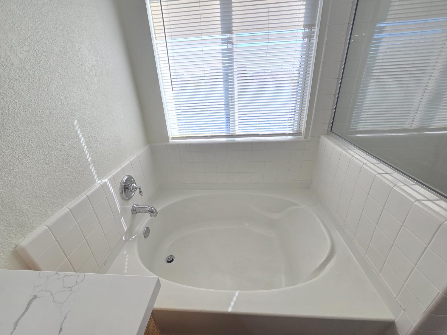 10554 Rudder Way Stockton, CA 95209 - Photo 16 of 40 a white bath tub sitting in a bathroom next to a window