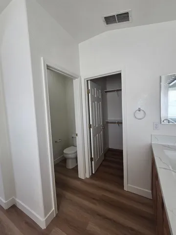 a large kitchen with a large counter top a sink stainless steel appliances and cabinets