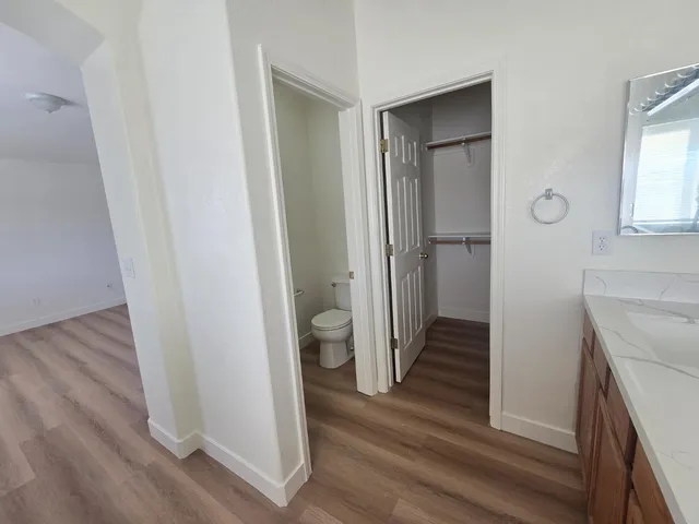 a kitchen with stainless steel appliances a stove a sink a microwave a refrigerator a cabinets and wooden floor