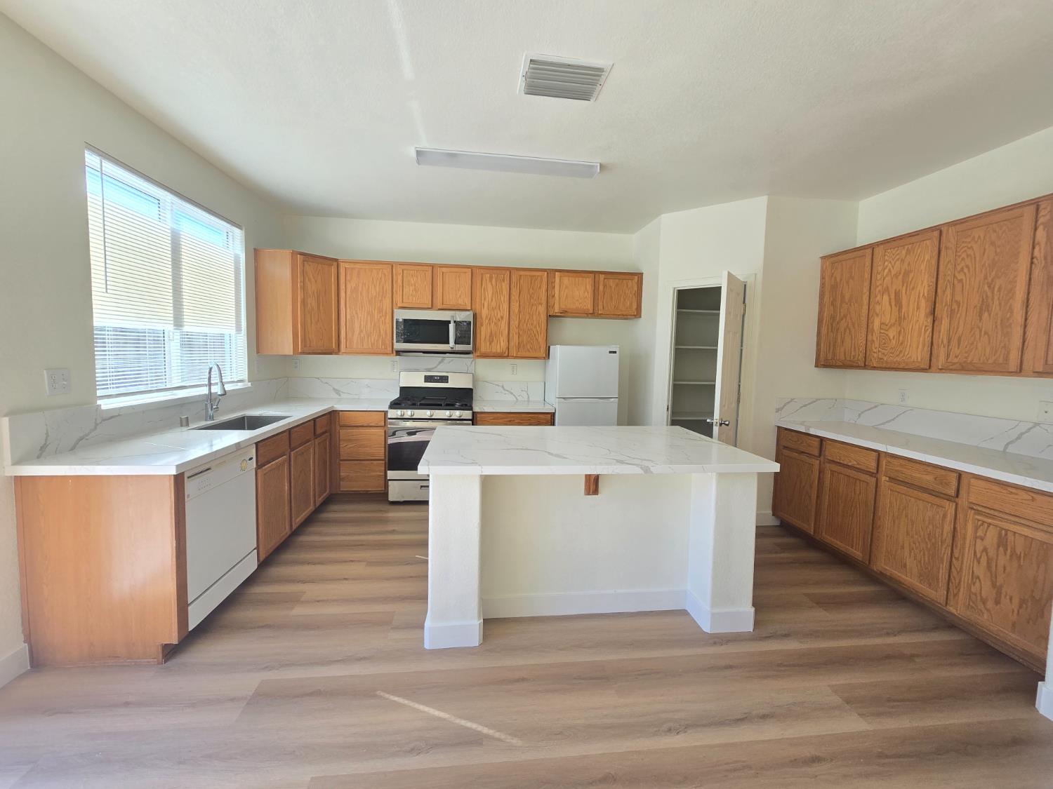10554 Rudder Way Stockton, CA 95209 - Photo 26 of 40 a large kitchen with a large counter top a sink stainless steel appliances and cabinets