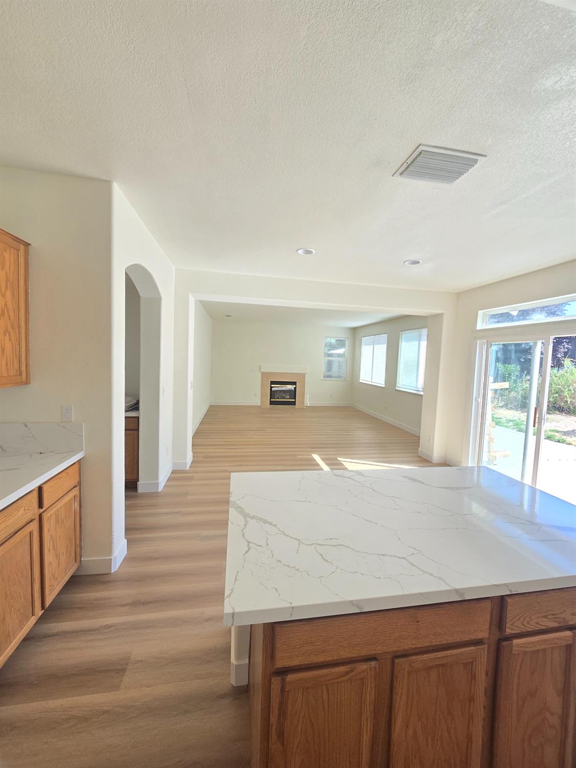 10554 Rudder Way Stockton, CA 95209 - Photo 30 of 40 a living room with stainless steel appliances kitchen island granite countertop a refrigerator a sink dishwasher and wooden cabinets with wooden floor