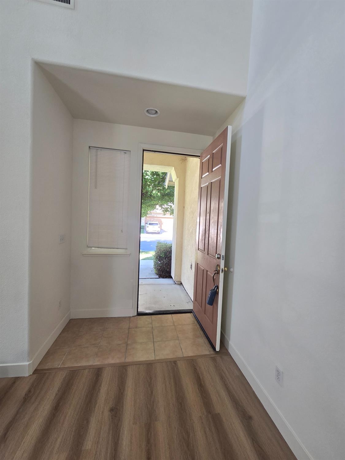 10554 Rudder Way Stockton, CA 95209 - Photo 5 of 40 a view of an empty room with wooden floor and a window