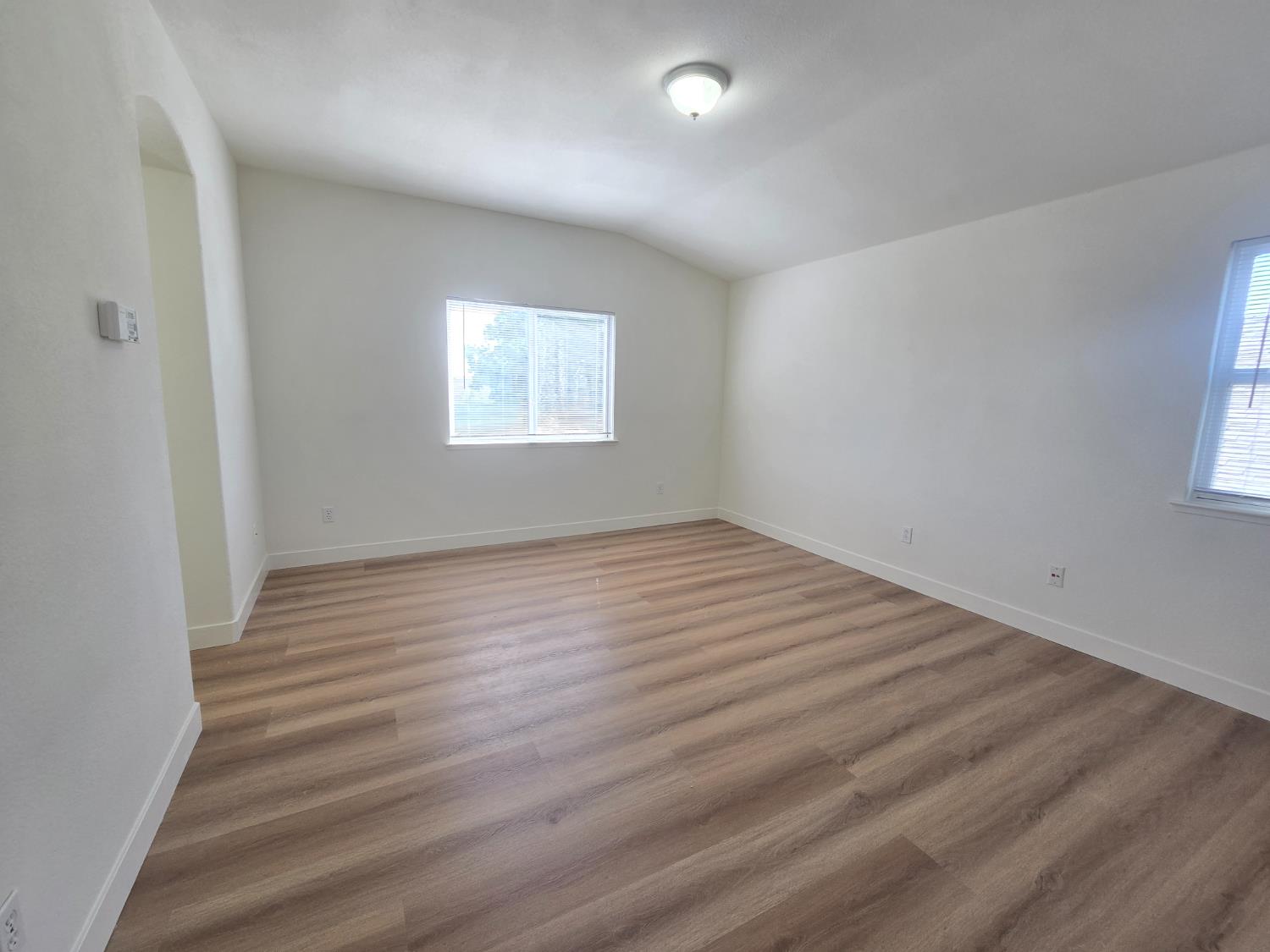 10554 Rudder Way Stockton, CA 95209 - Photo 7 of 40 an empty room with wooden floor and windows