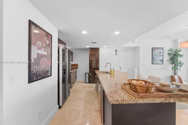 a kitchen with stainless steel appliances granite countertop a sink a stove and a refrigerator