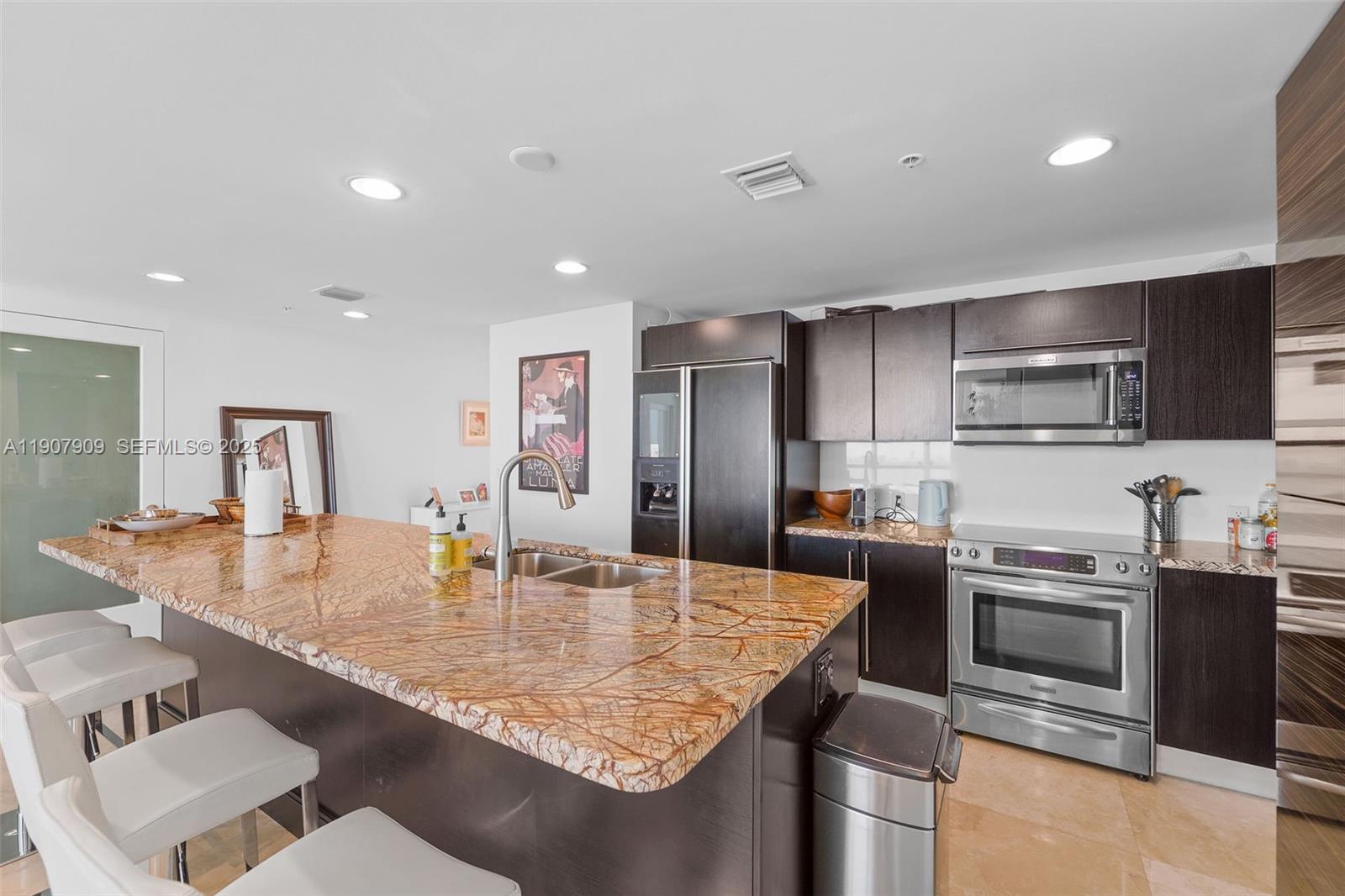 665 Northeast 25th Street, Unit PHI01 Miami, FL 33137 - Photo 14 of 38 a kitchen with stainless steel appliances granite countertop a sink a stove and a refrigerator