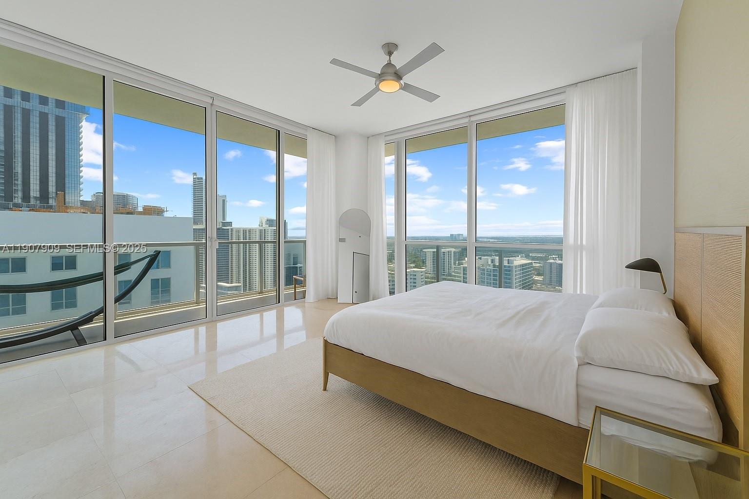 665 Northeast 25th Street, Unit PHI01 Miami, FL 33137 - Photo 22 of 38 a bed sitting in a spacious bedroom next to a window