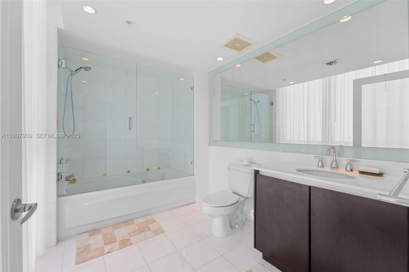 665 Northeast 25th Street, Unit PHI01 Miami, FL 33137 - Photo 31 of 38 a bathroom with a bathtub shower sink mirror and toilet