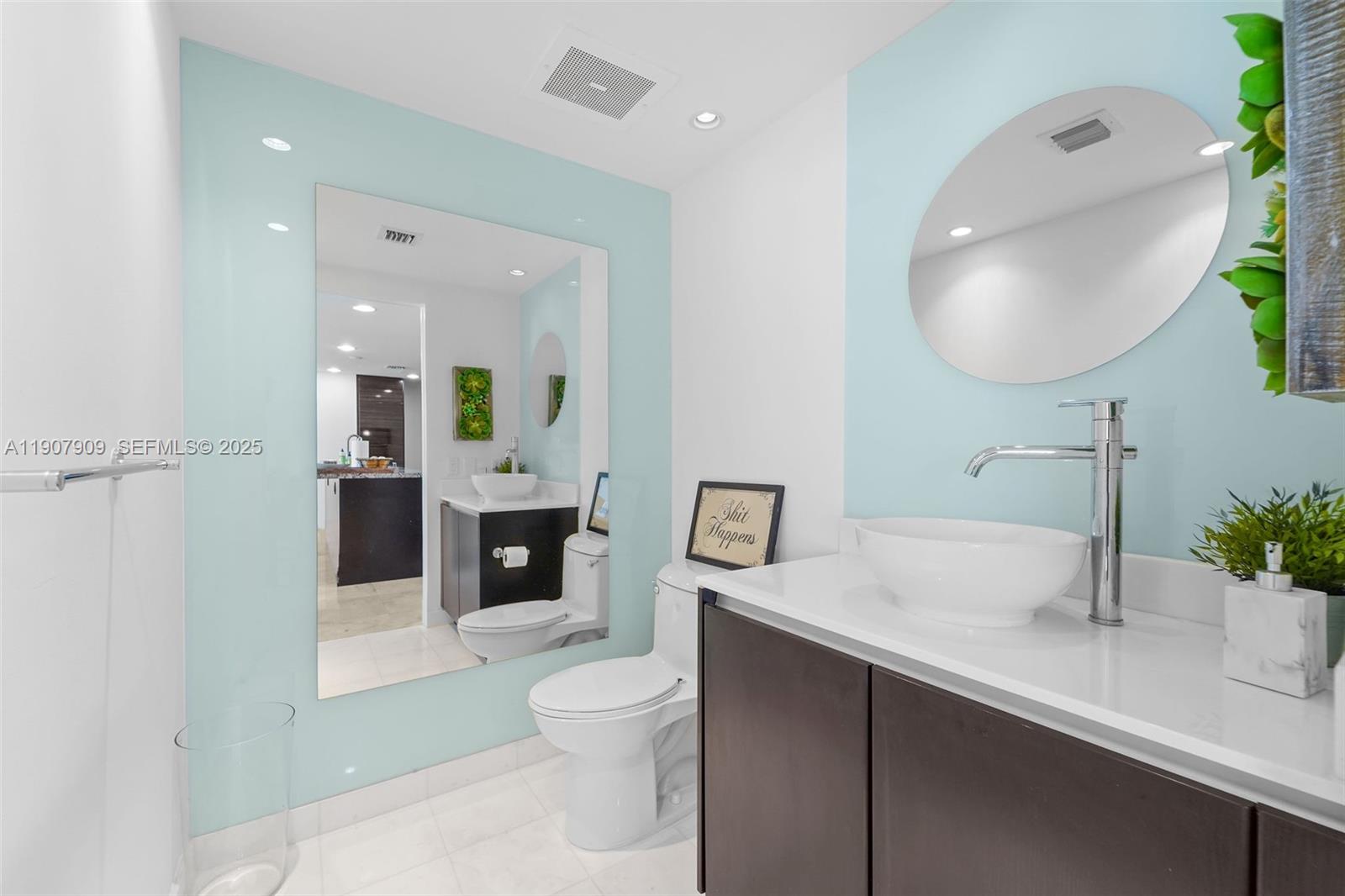 665 Northeast 25th Street, Unit PHI01 Miami, FL 33137 - Photo 35 of 38 a spacious bathroom with a toilet sink and mirror