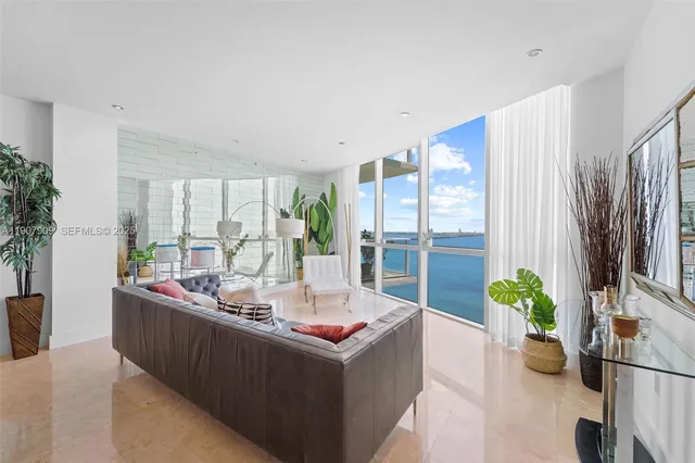 a living room with furniture potted plant and a large window