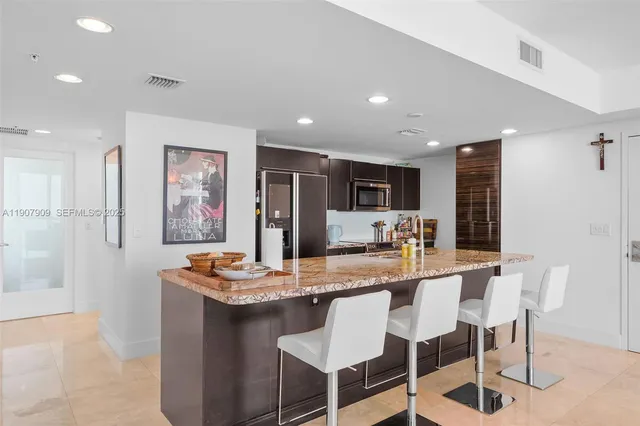a dining room with kitchen island a dining table wooden floor and kitchen view