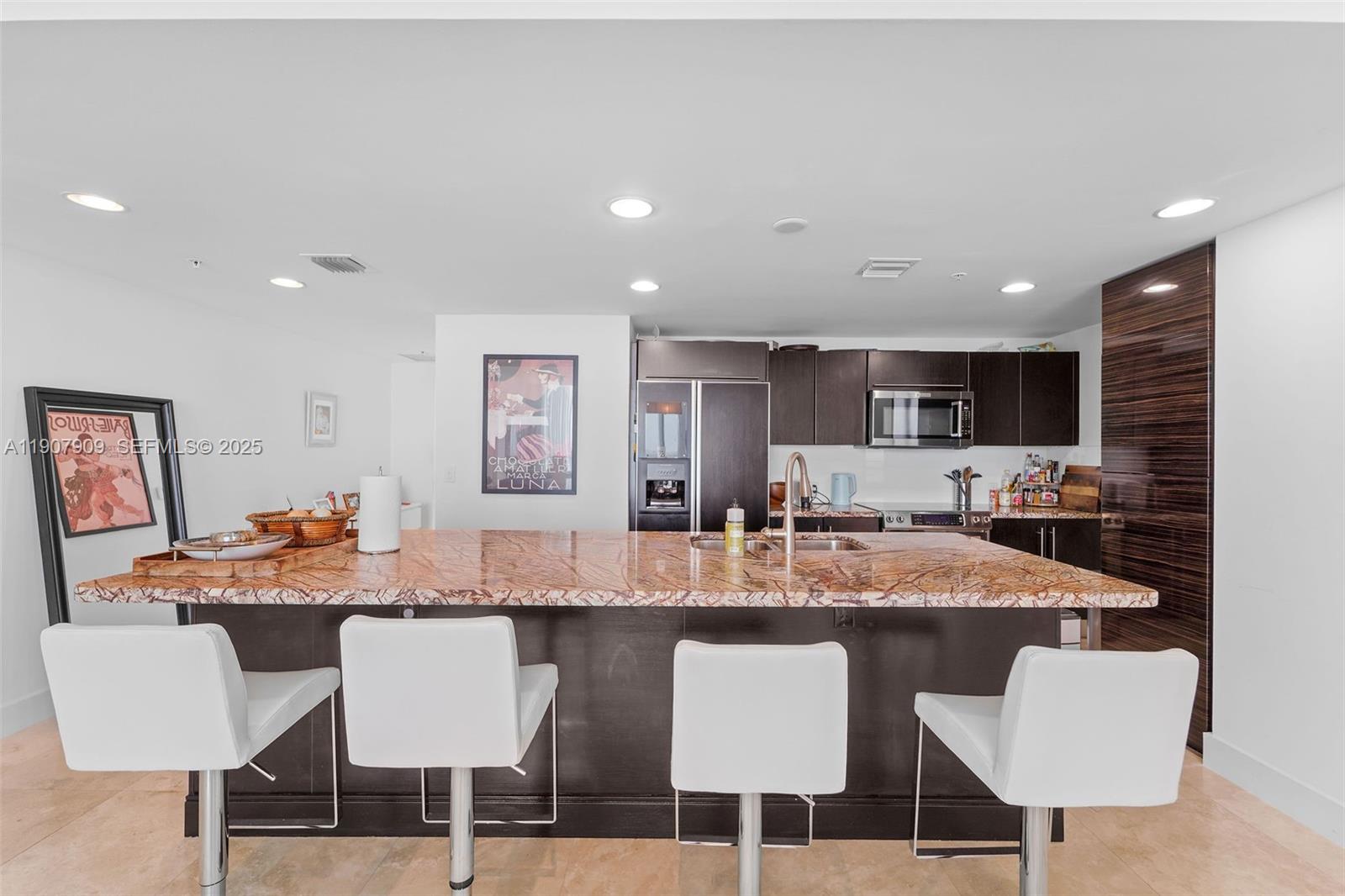 665 Northeast 25th Street, Unit PHI01 Miami, FL 33137 - Photo 9 of 38 a dining room with kitchen island a dining table wooden floor and kitchen view
