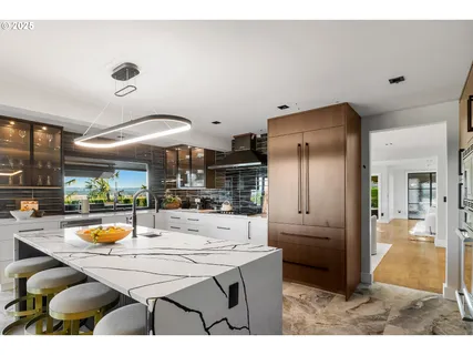 a kitchen with stainless steel appliances kitchen island granite countertop a refrigerator and a sink