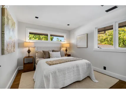 a bedroom with a bed and two windows