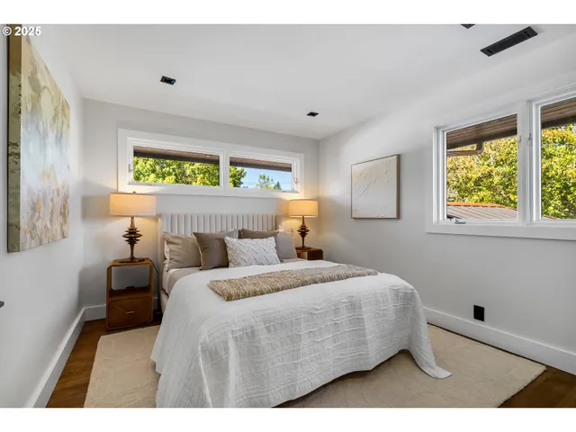 a bedroom with a bed and two windows