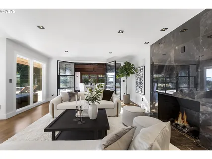 a living room with furniture a large window and a fireplace