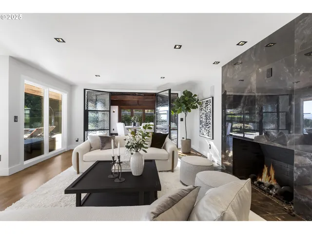 a living room with furniture a large window and a fireplace