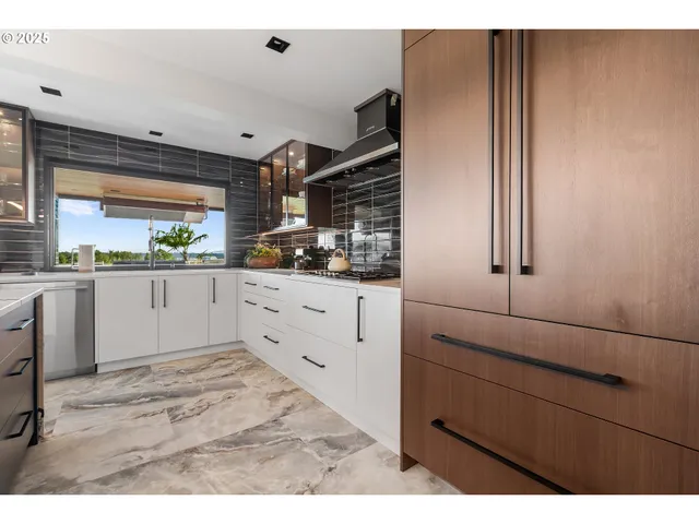 a kitchen with a sink window and cabinets