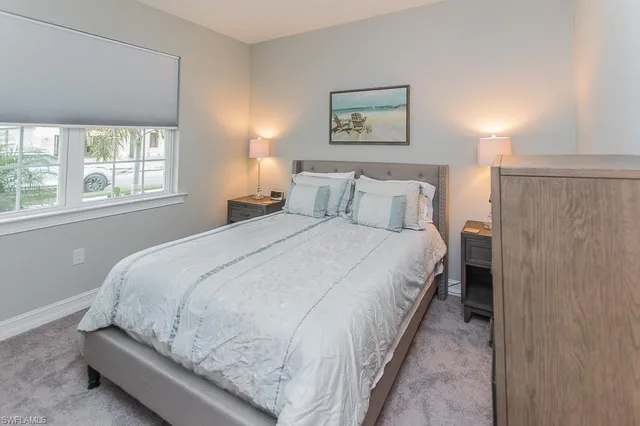 a large bed sitting in a bedroom next to a window