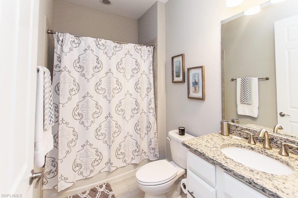 14670 Catamaran Place Naples, FL 34114 - Photo 16 of 24 a bathroom with a granite countertop sink a toilet and a mirror