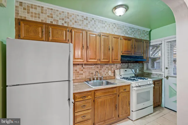 a kitchen with stainless steel appliances granite countertop a refrigerator sink stove and cabinets